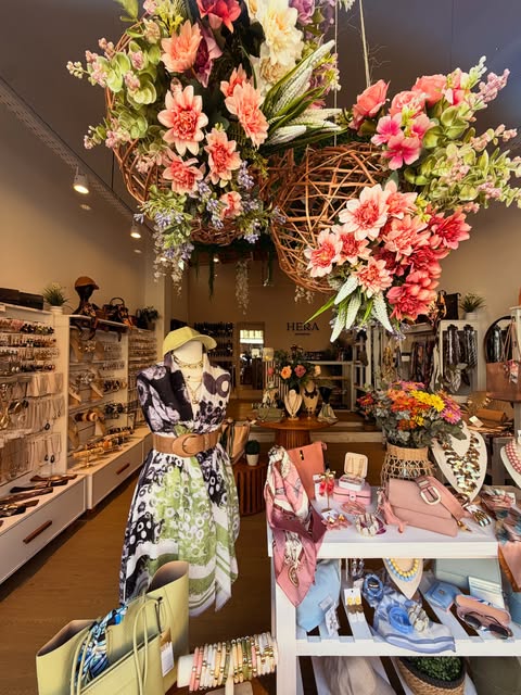 Flores de colores sobre la exhibición de carteras y accesorios de Hera